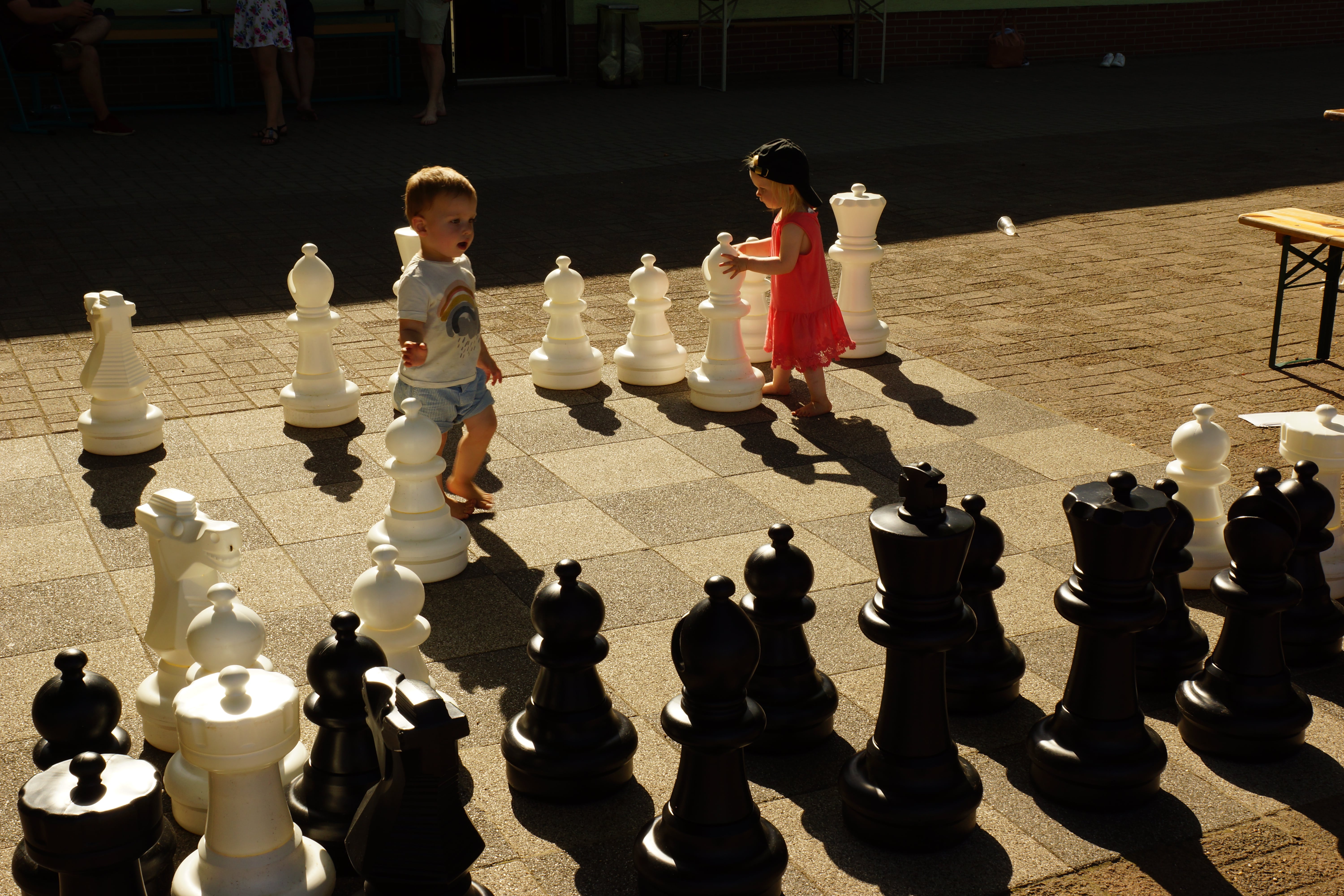 Kinder spielen auf dem Großschachbrett